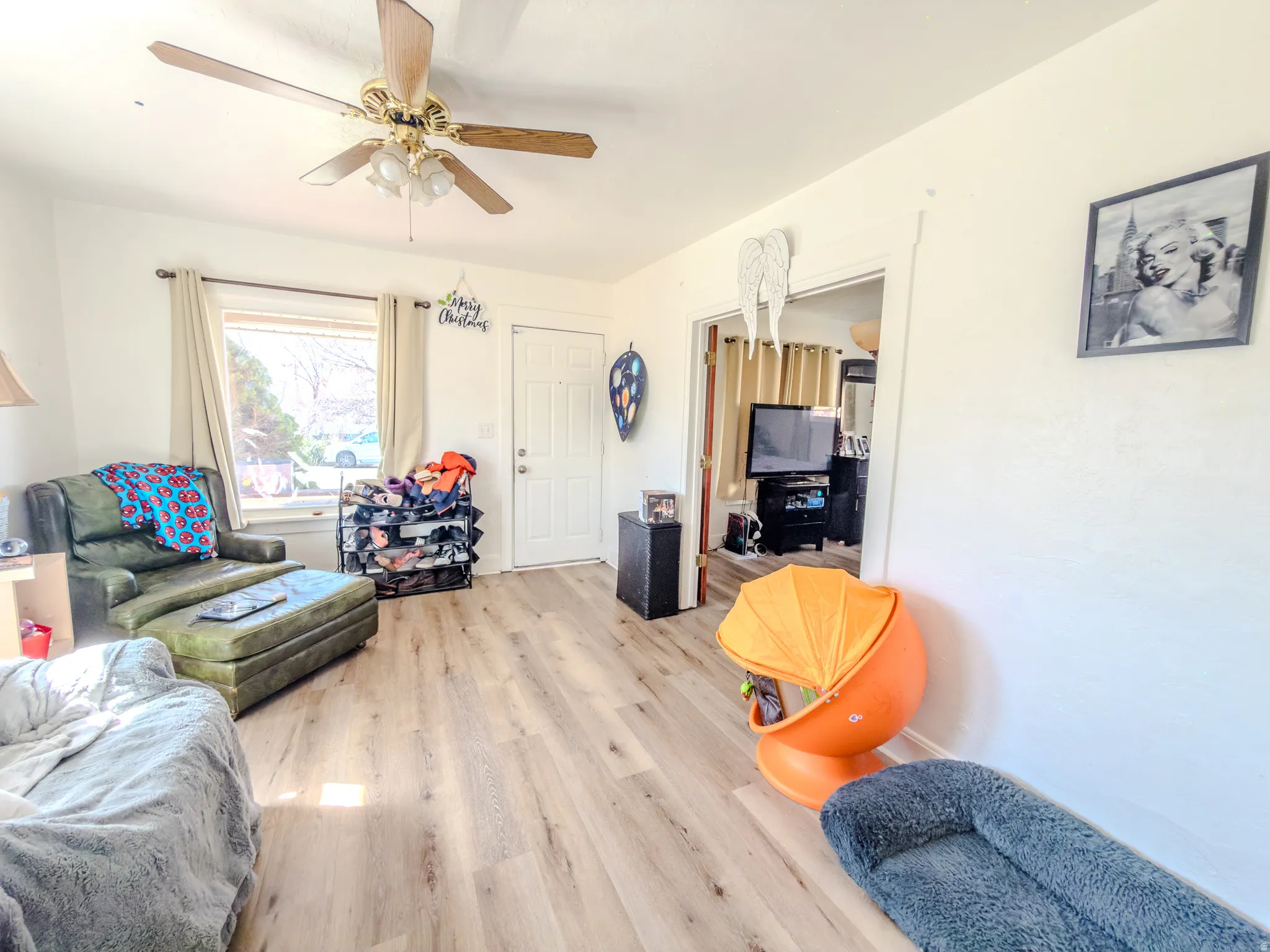 Living area with light wood-style flooring and a ceiling fan