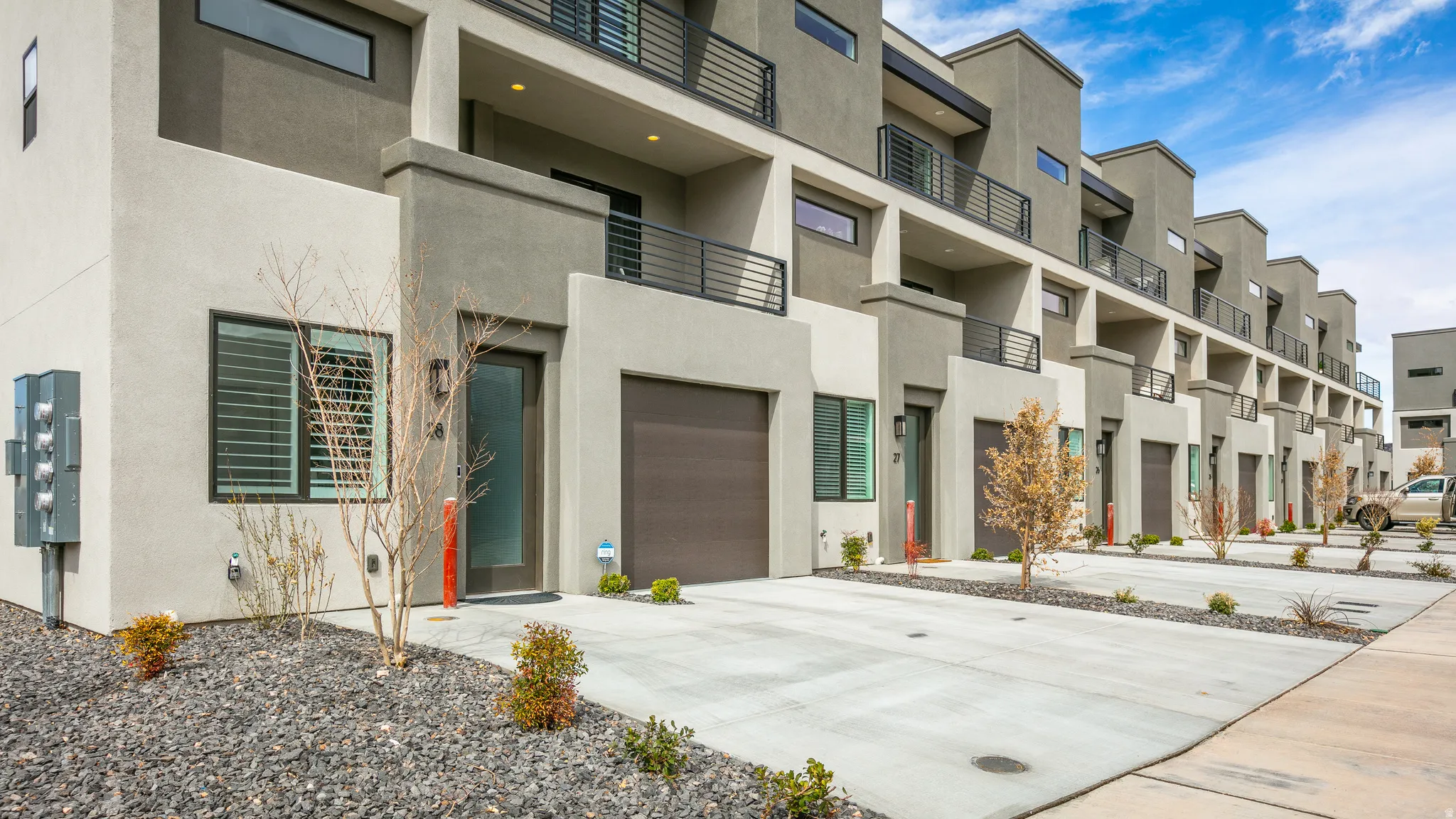 View of property featuring an attached garage and concrete driveway
