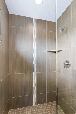 Bathroom with a shower stall and a textured ceiling