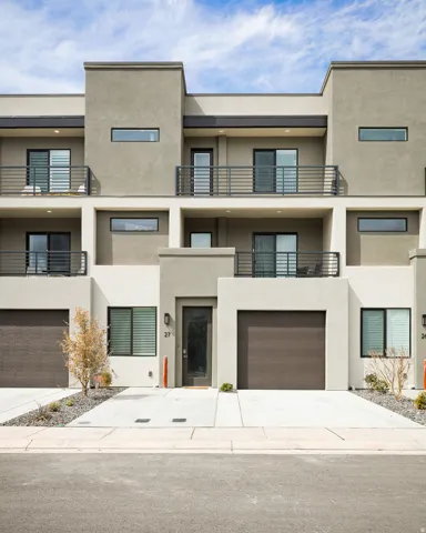 View of apartment building / complex featuring driveway and a garage