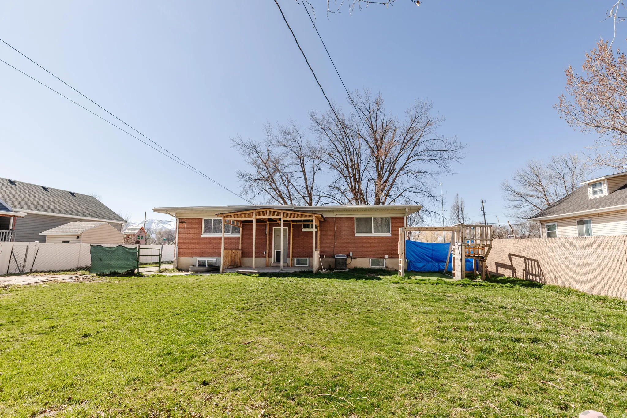 Back of property featuring a fenced backyard, brick siding, and a patio