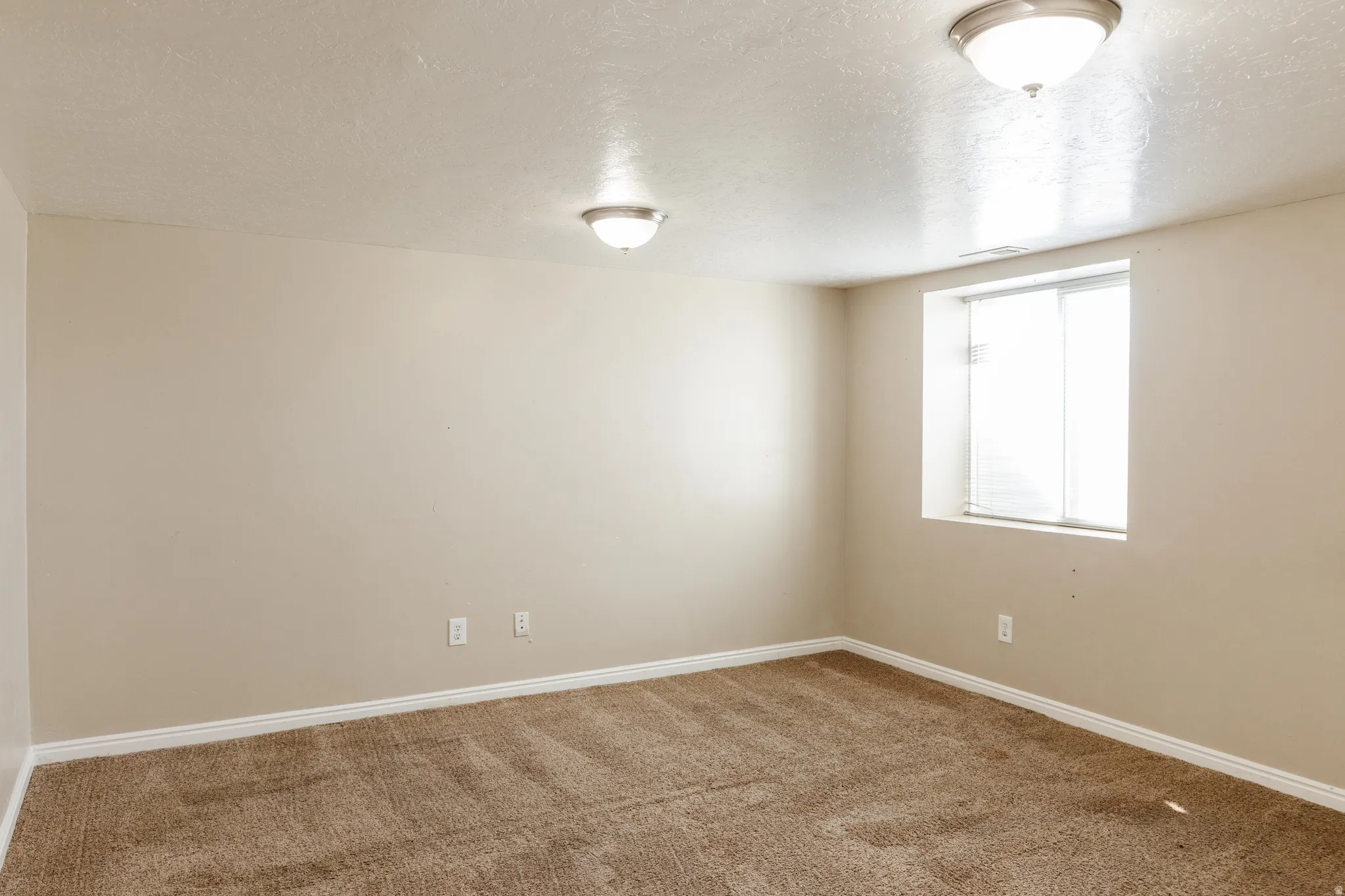 Spare room featuring a textured ceiling and carpet flooring