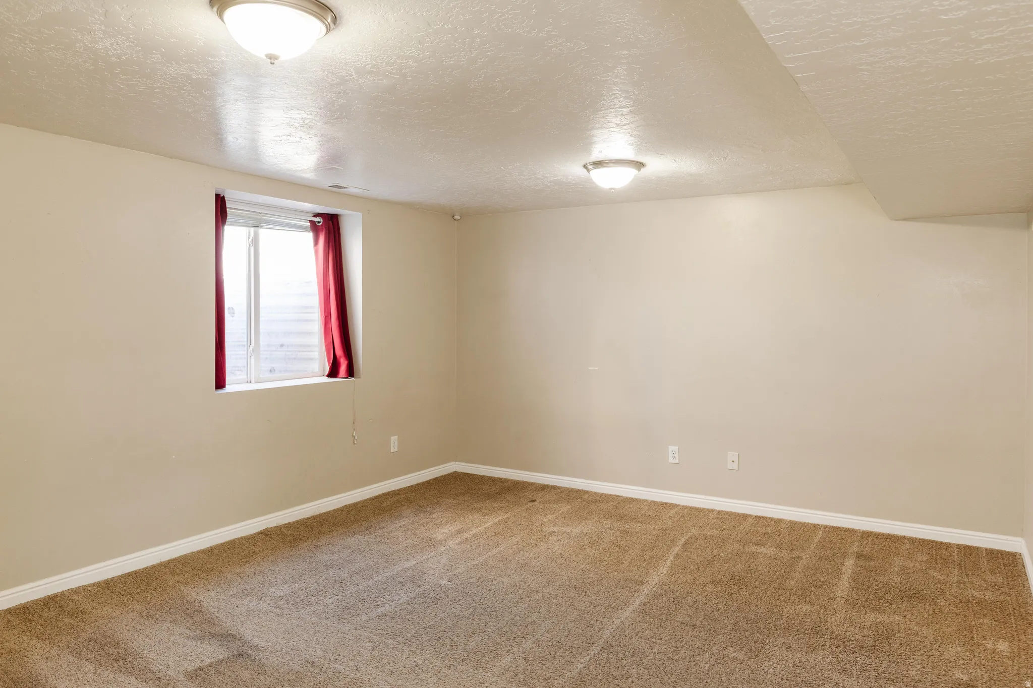 Spare room featuring a textured ceiling and carpet floors