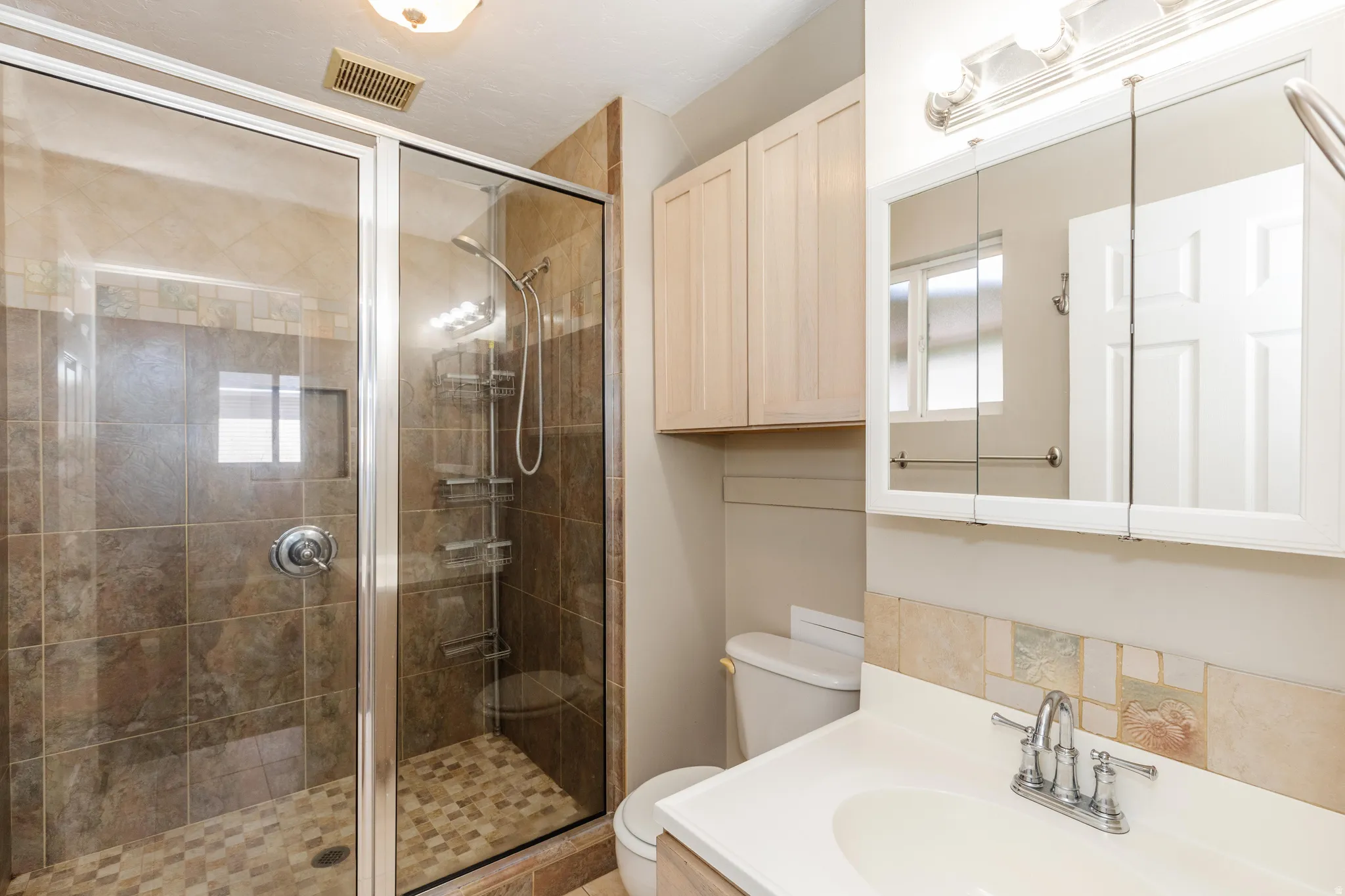 Full bath with vanity and a shower stall