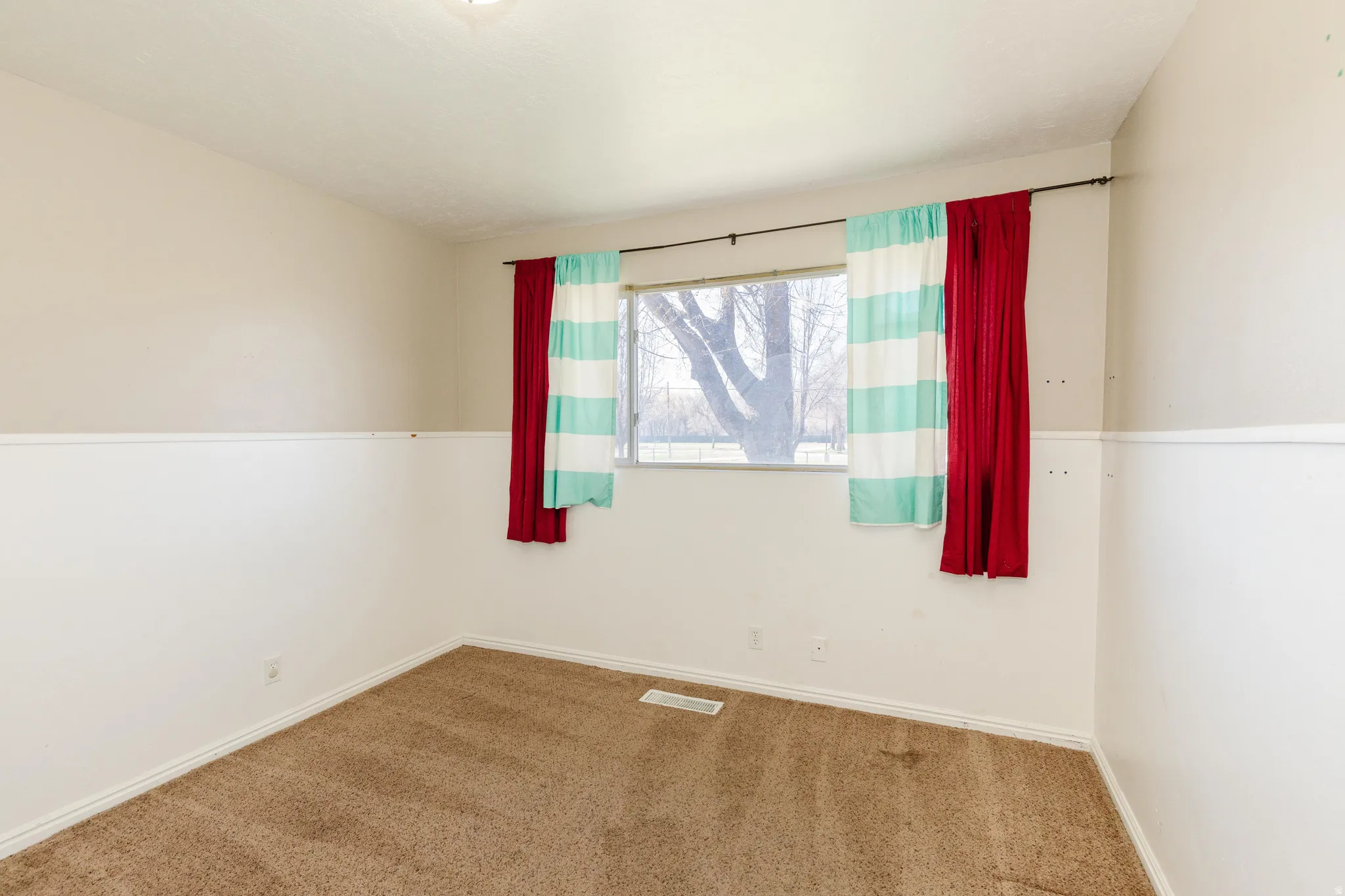 Empty room featuring carpet and baseboards