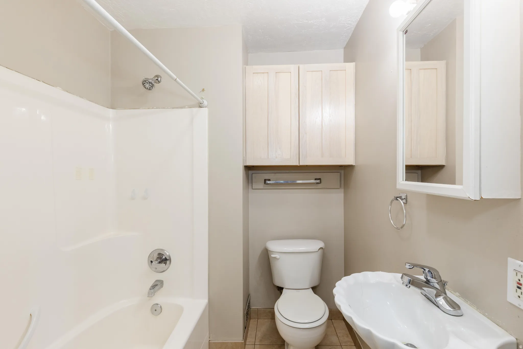 Full bath featuring  shower combination and light tile patterned floors