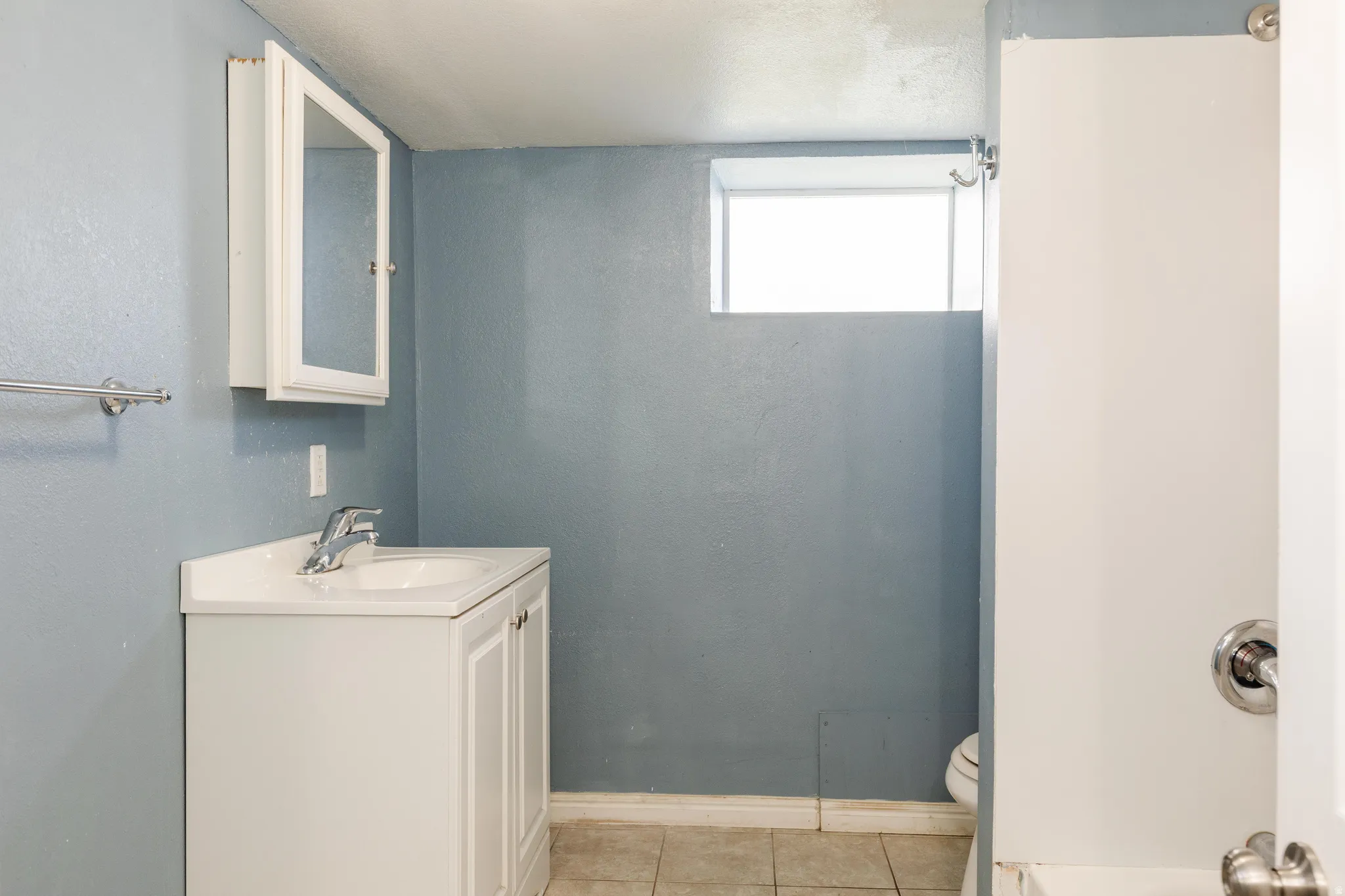 Full bathroom with vanity and light tile patterned floors