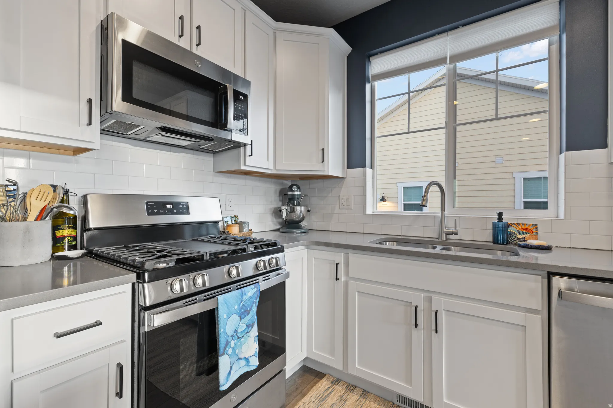 Kitchen featuring stainless steel appliances, white cabinets, and plenty of natural light