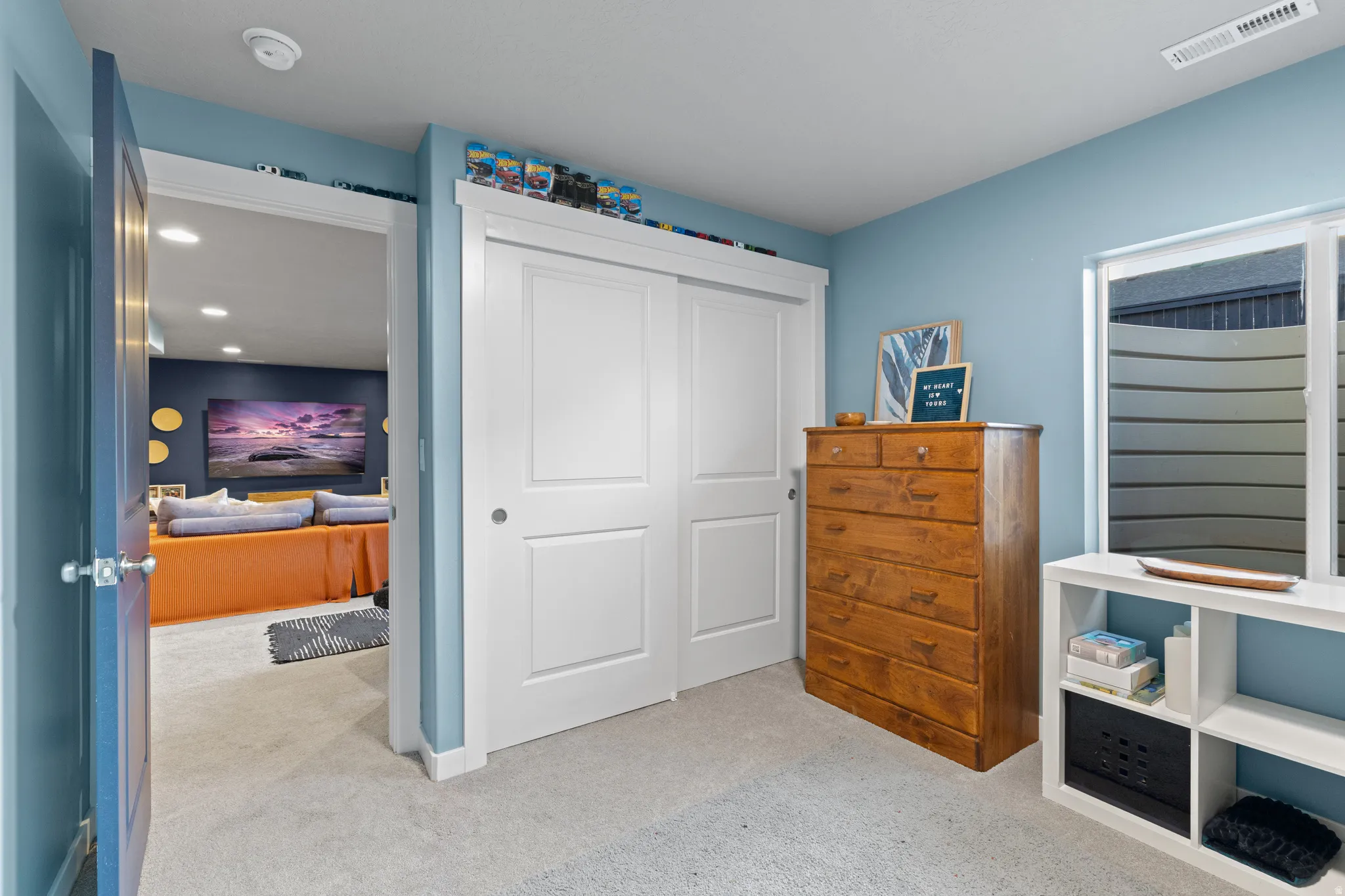 Bedroom featuring light carpet and a closet