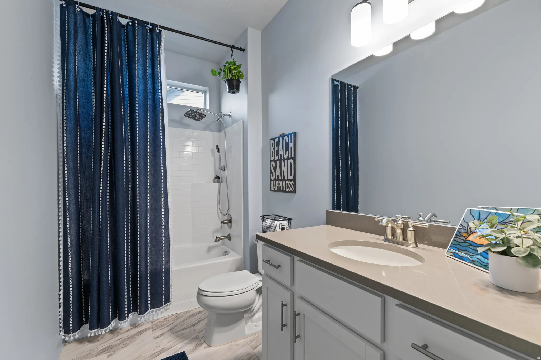 Full bath featuring vanity, shower / bath combo with shower curtain, and light wood-style floors