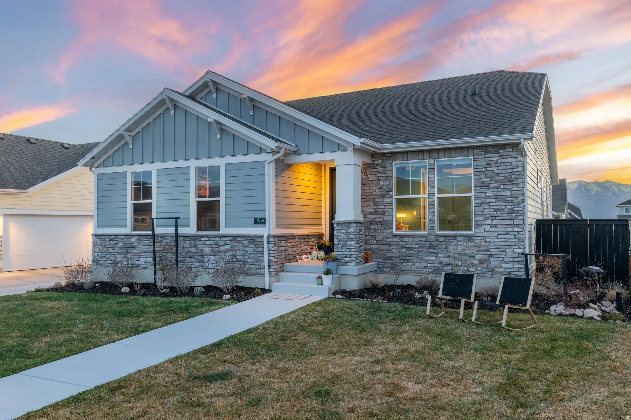 Craftsman-style home featuring stone siding, board and batten siding, and roof with shingles