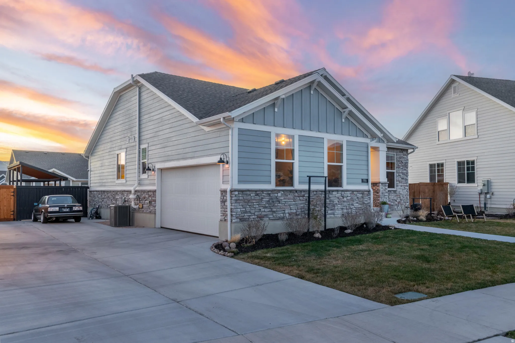 Craftsman house with stone siding, board and batten siding, driveway, and an attached garage