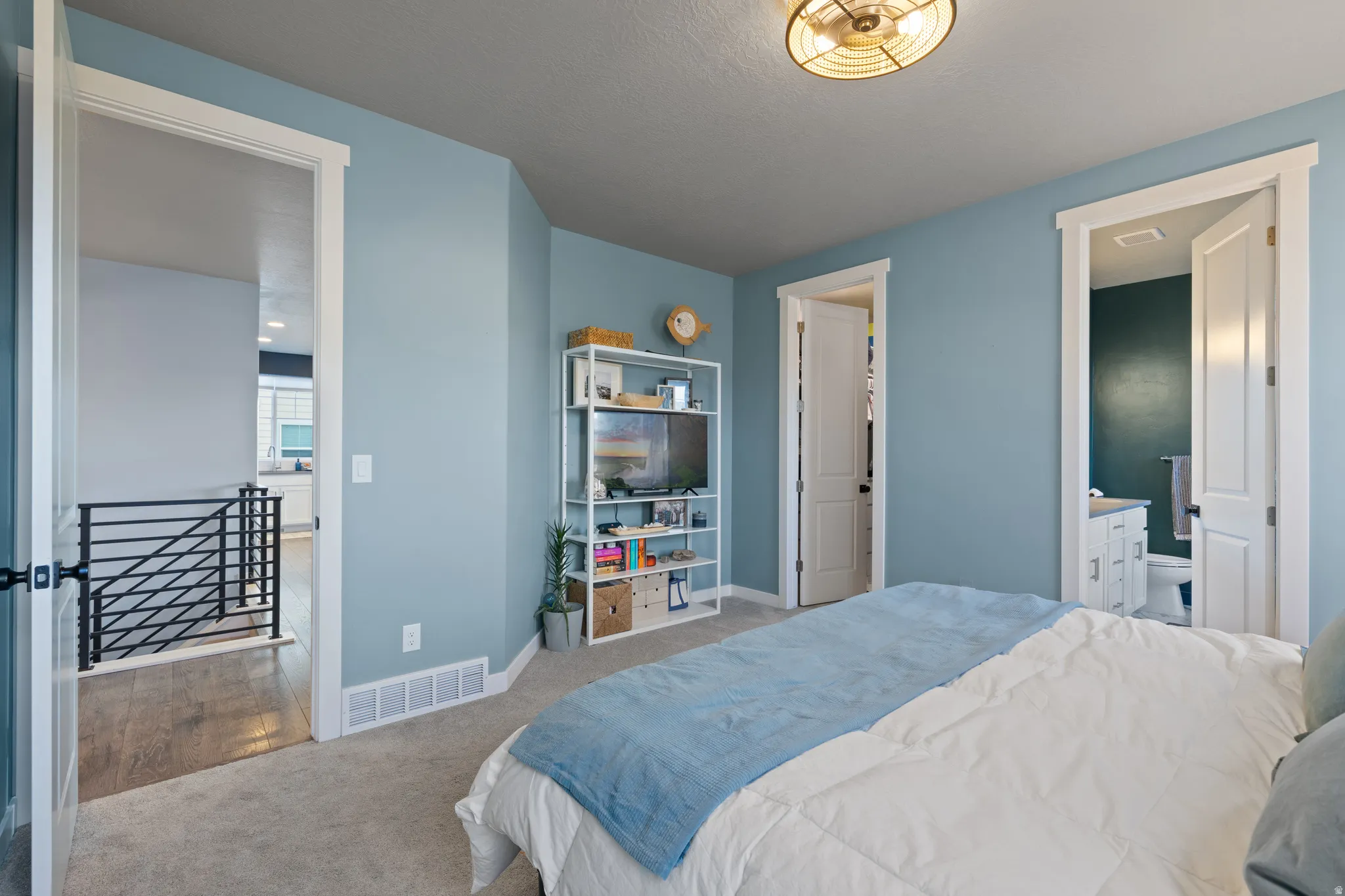 Bedroom with carpet floors and ensuite bathroom