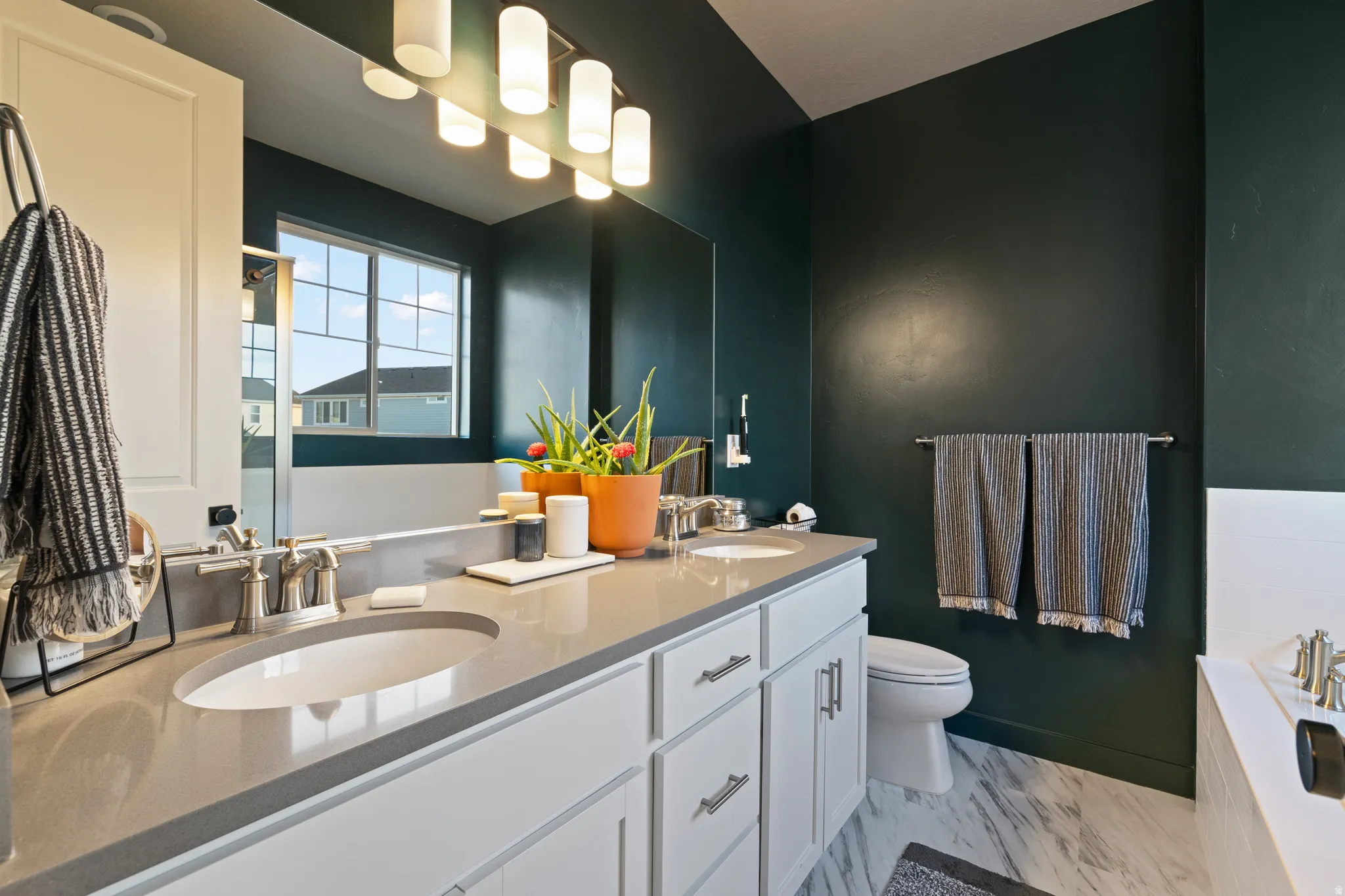 Full bath with double vanity and a garden tub