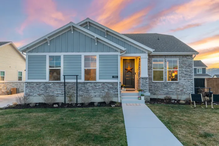 View of front of home featuring stone siding, board and batten siding, and a shingled roof