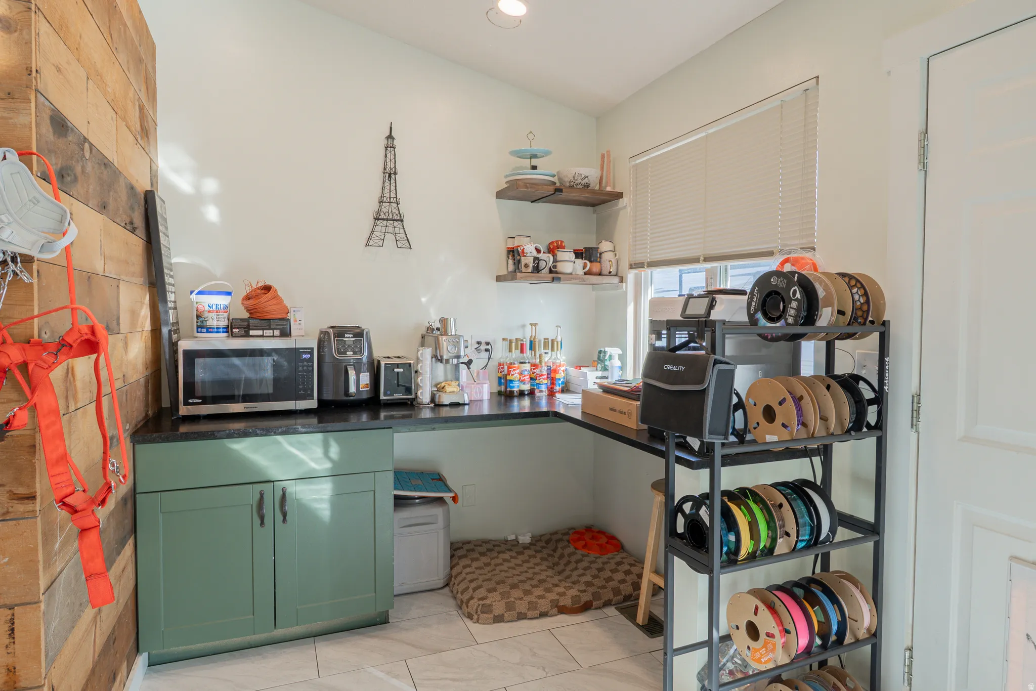 Kitchen featuring dark countertops, green cabinetry, and stainless steel microwave
