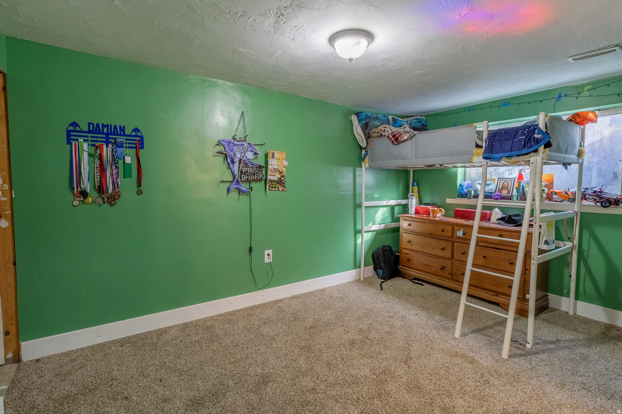 Bedroom featuring light carpet and a textured ceiling