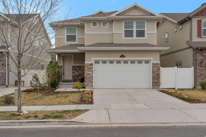 View of front of house featuring driveway, stone siding, a garage, a gate, and a shingled roof