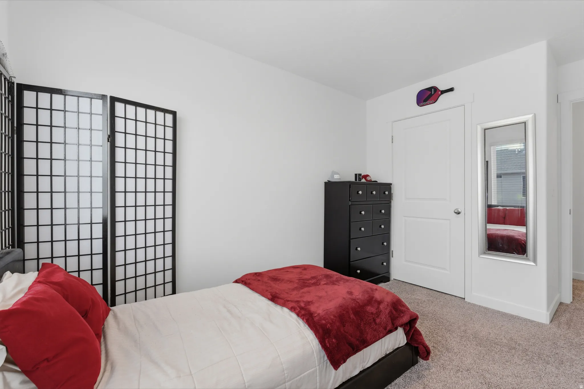 Bedroom with light carpet and a closet