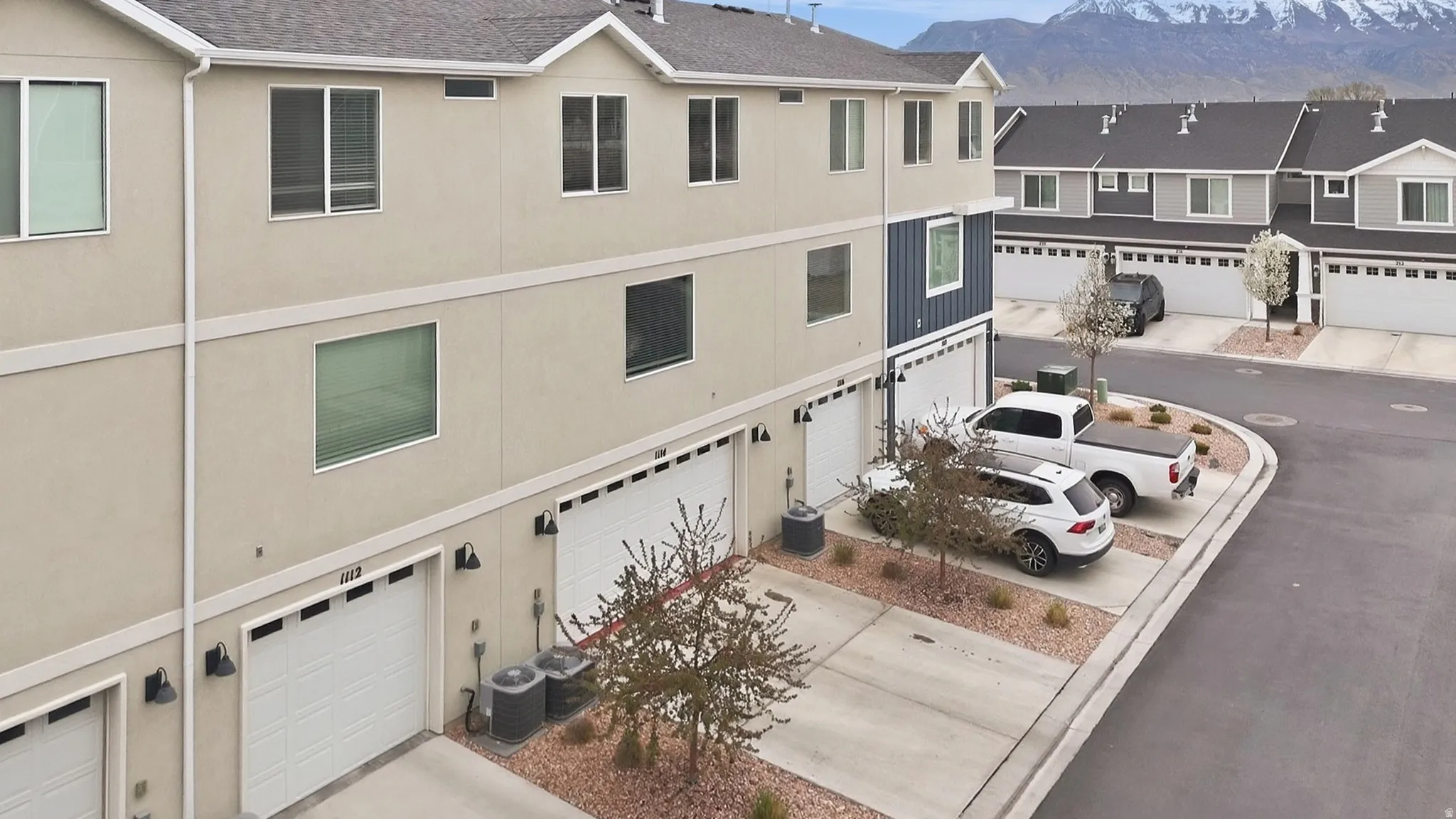 View of attached garage, concrete driveway, and a mountain view