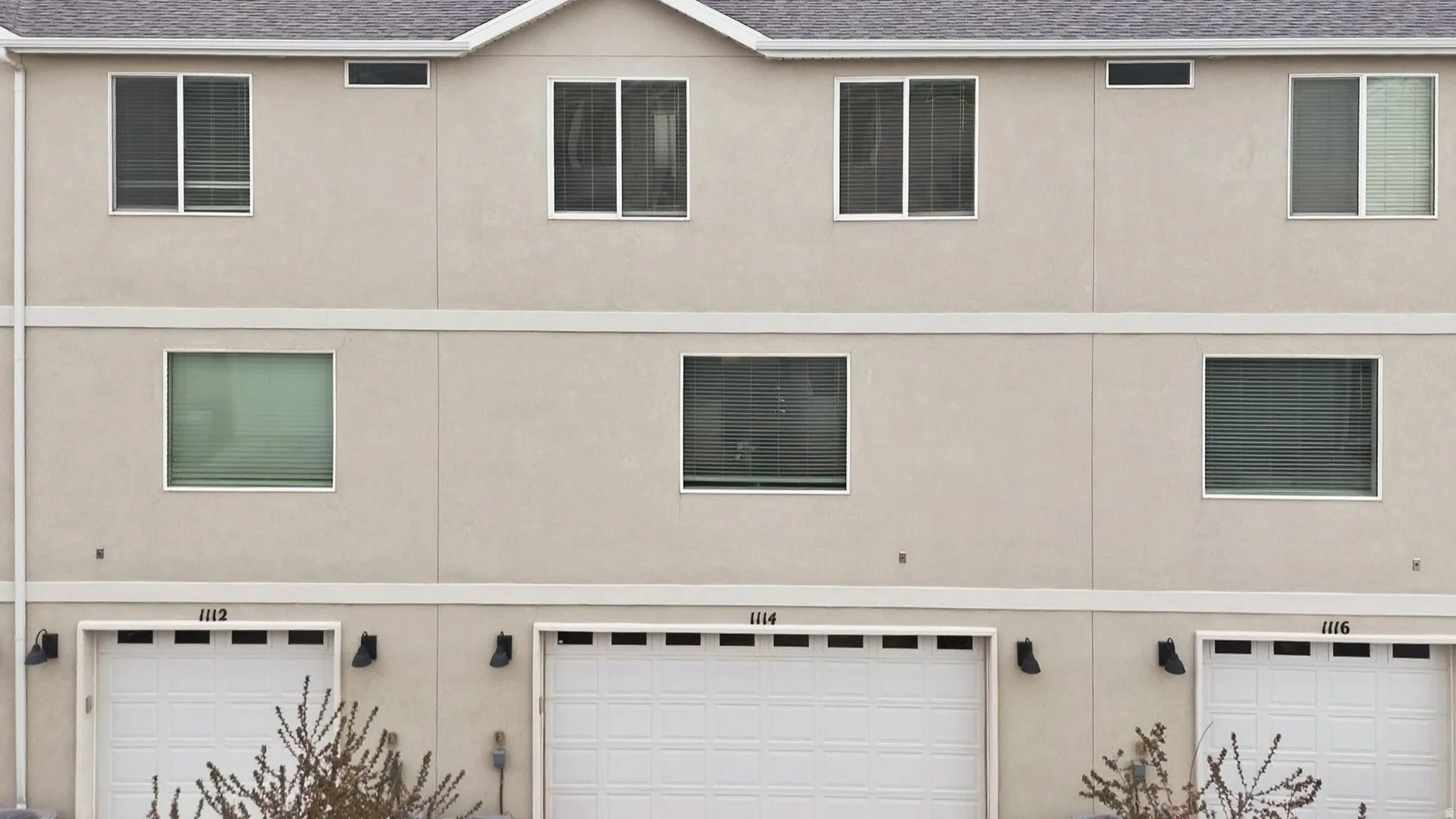 View of an attached garage, and stucco siding