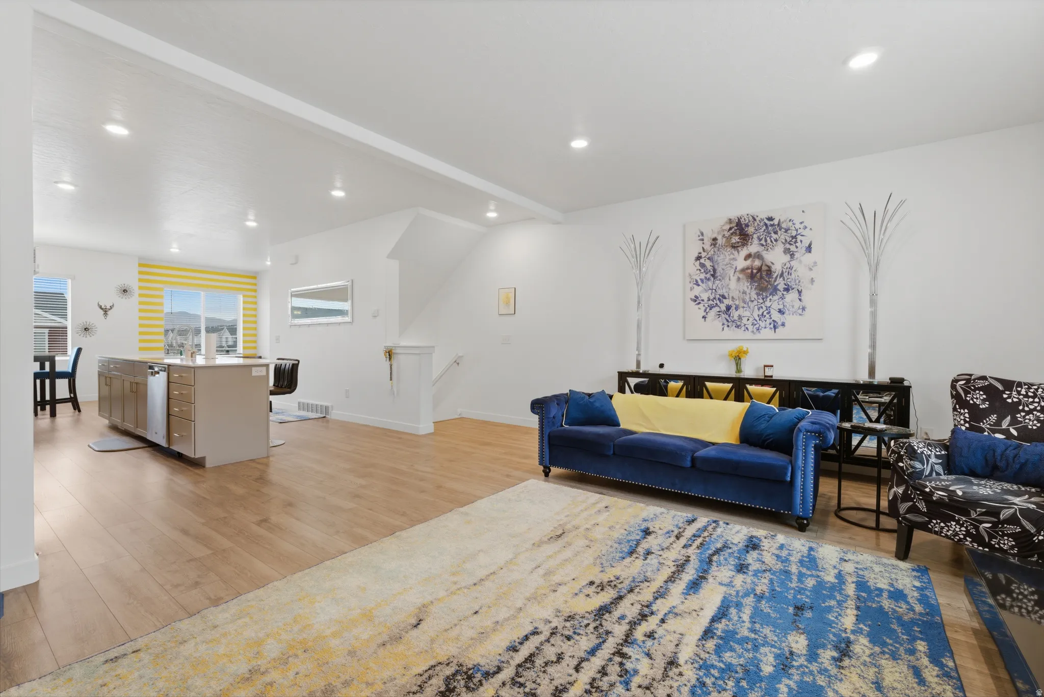 Living area featuring light wood finished floors, recessed lighting, and beamed ceiling
