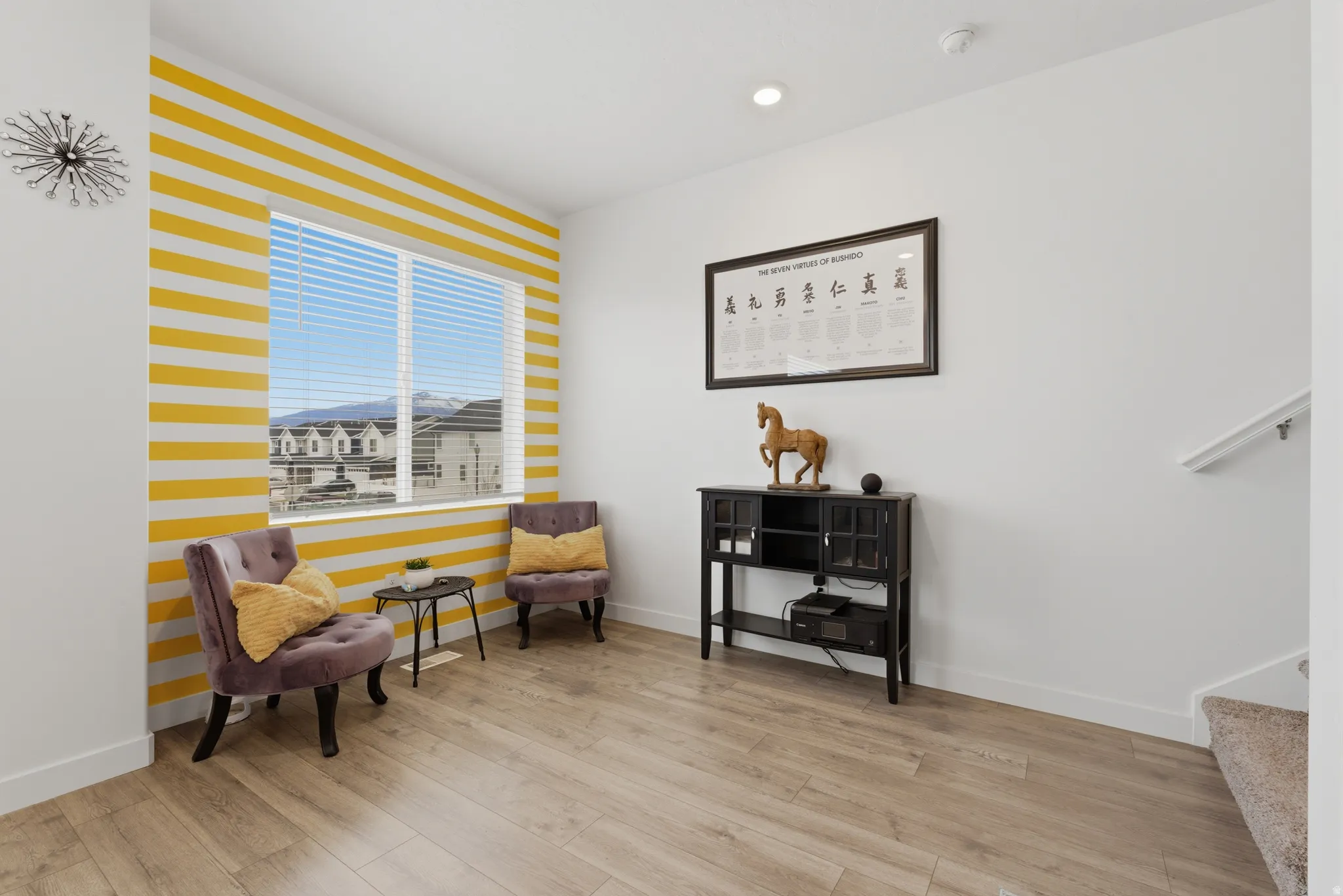 Sitting room with light wood-style floors, an accent wall, and recessed lighting