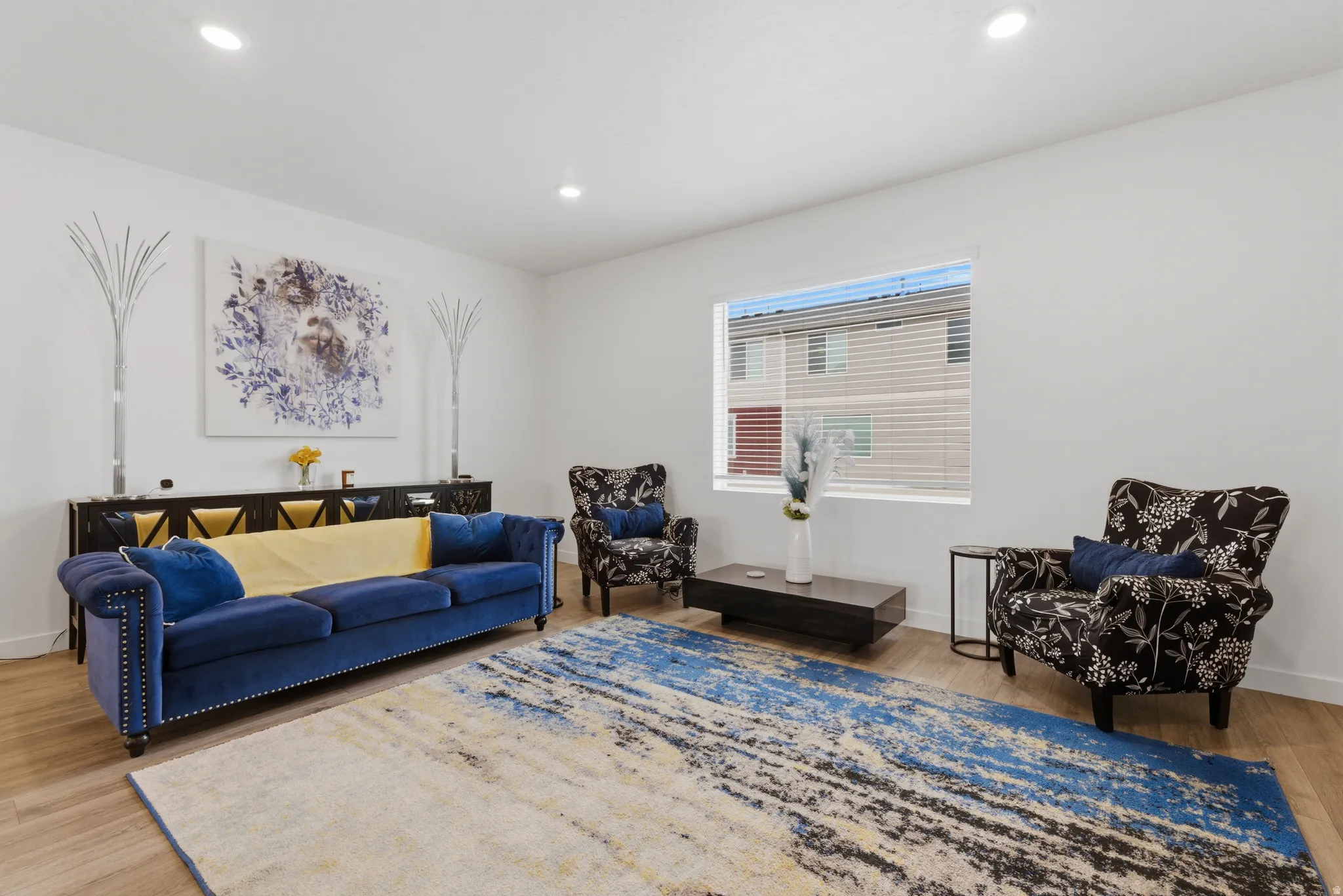 Living room with light wood-style flooring and recessed lighting