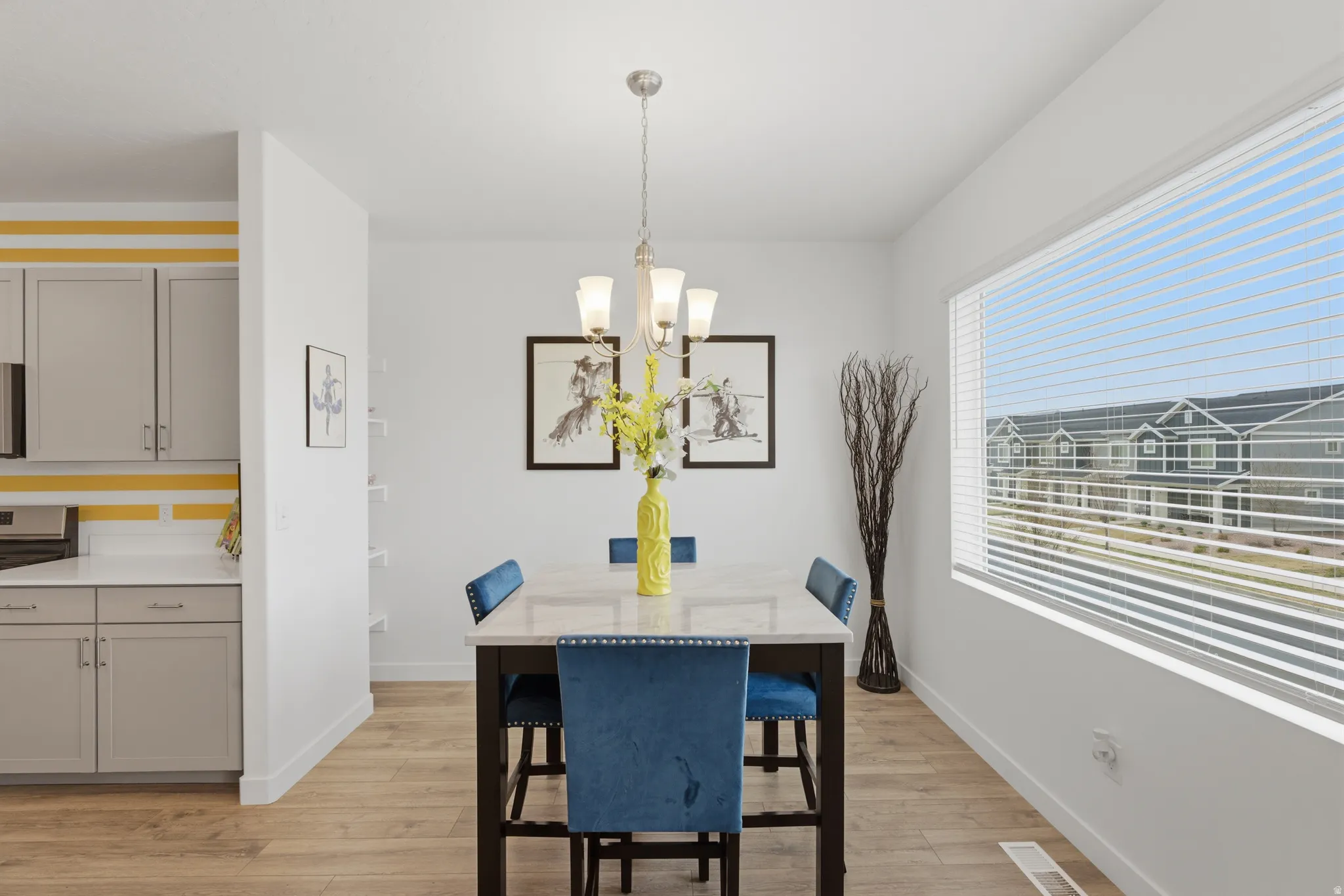 Dining room with light wood-style floors and suspended lighting