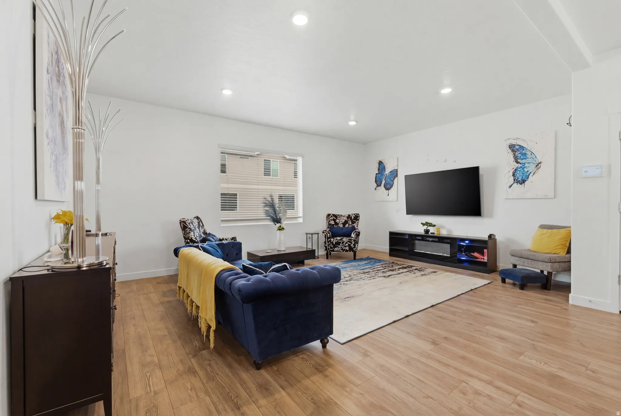 Living area with light wood-style flooring and recessed lighting