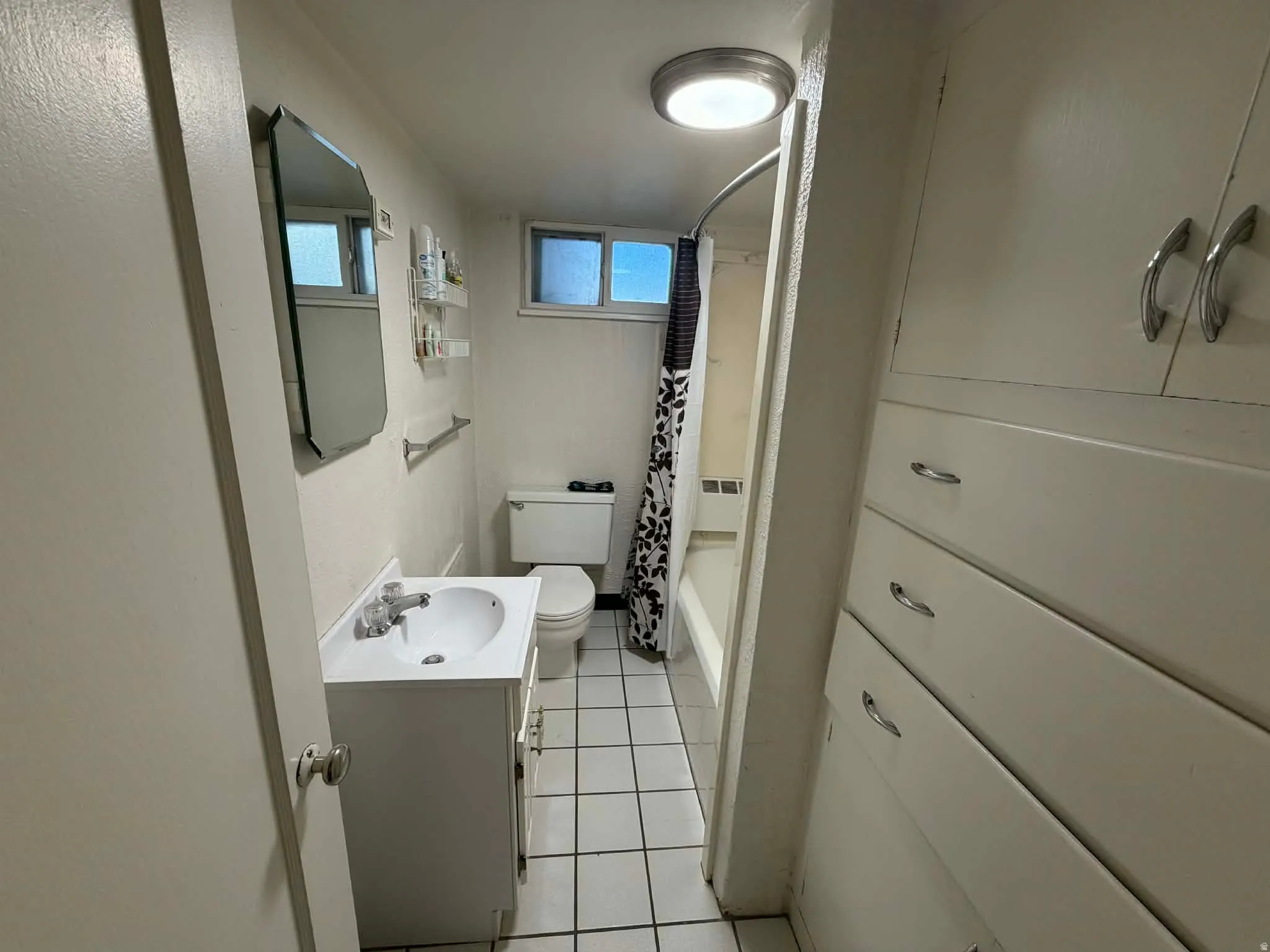 Full bathroom featuring vanity, light tile patterned floors, and shower / bath combo