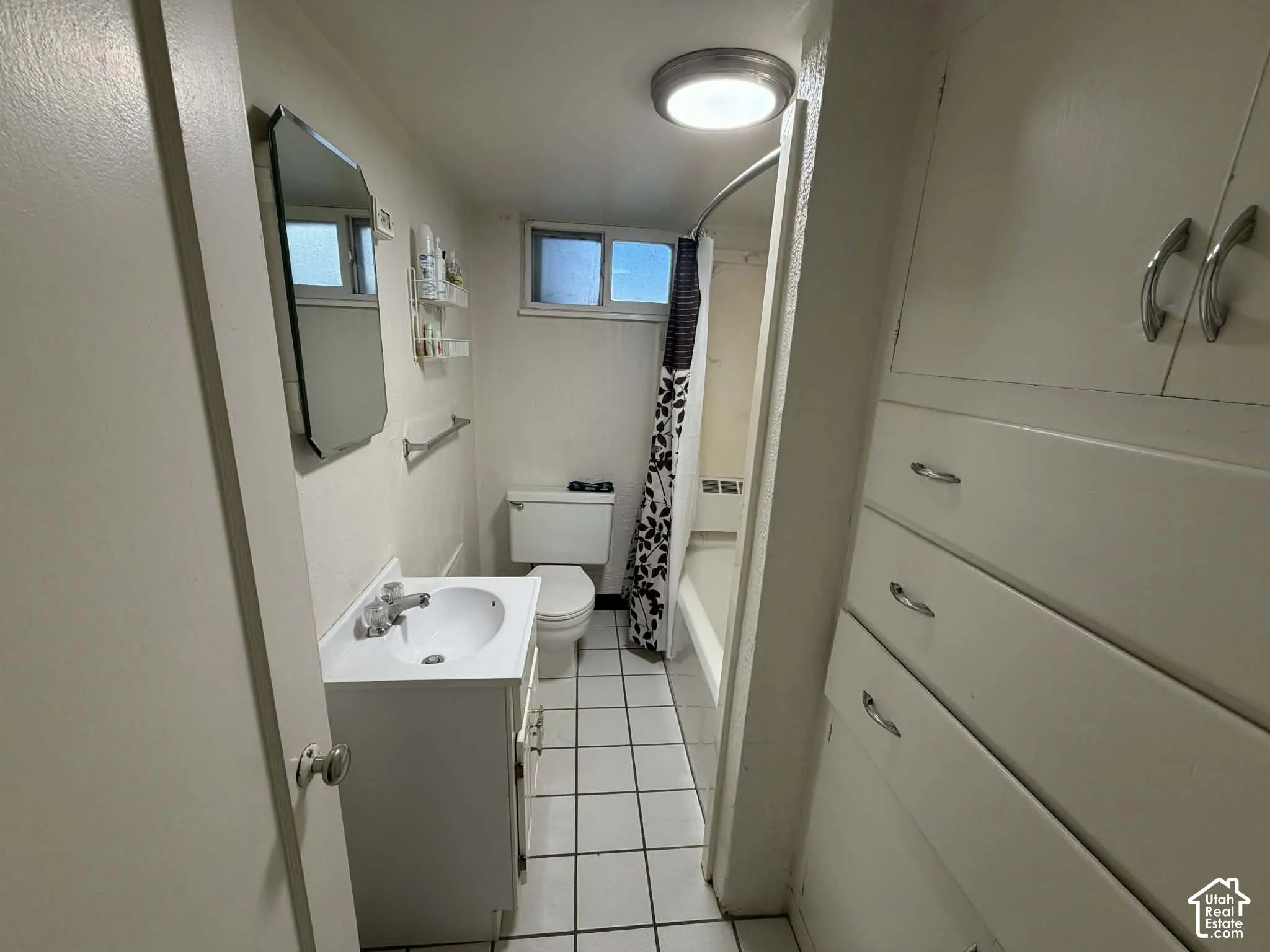 Full bathroom featuring vanity, light tile patterned floors, and shower / bath combo