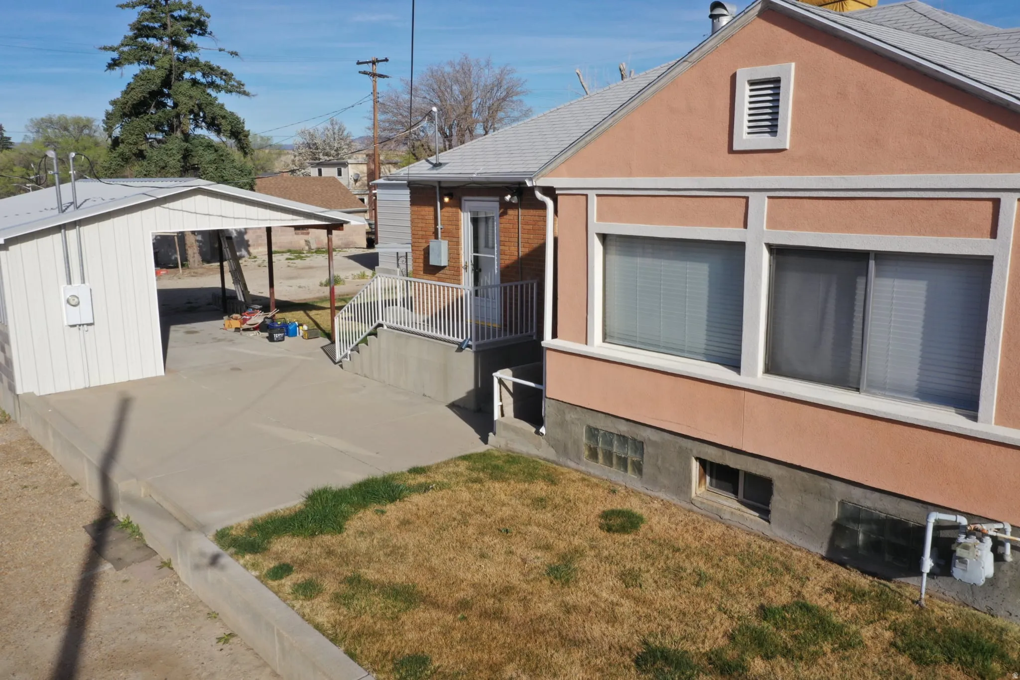 View of property exterior featuring a yard, stucco siding, and brick siding