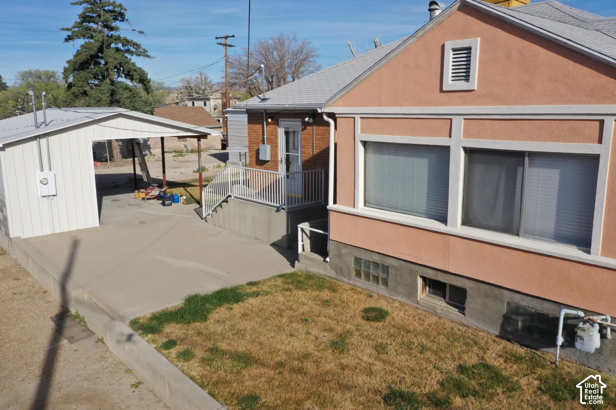 View of property exterior featuring a yard, stucco siding, and brick siding