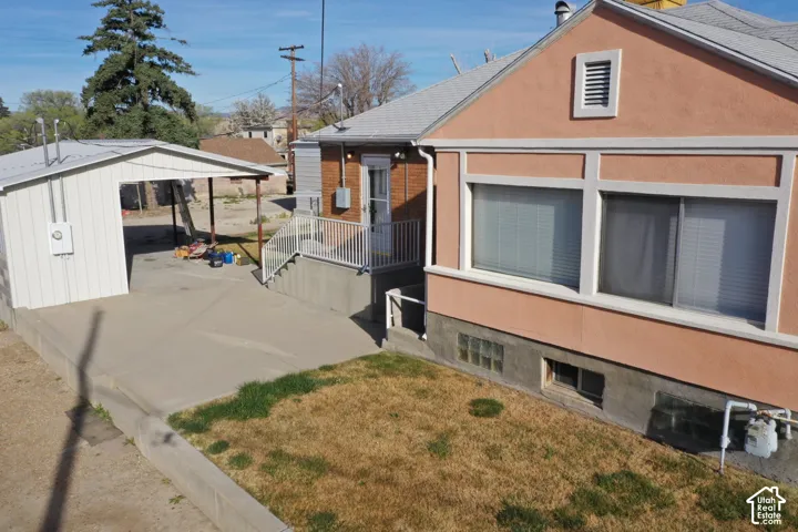 View of property exterior featuring a yard, stucco siding, and brick siding