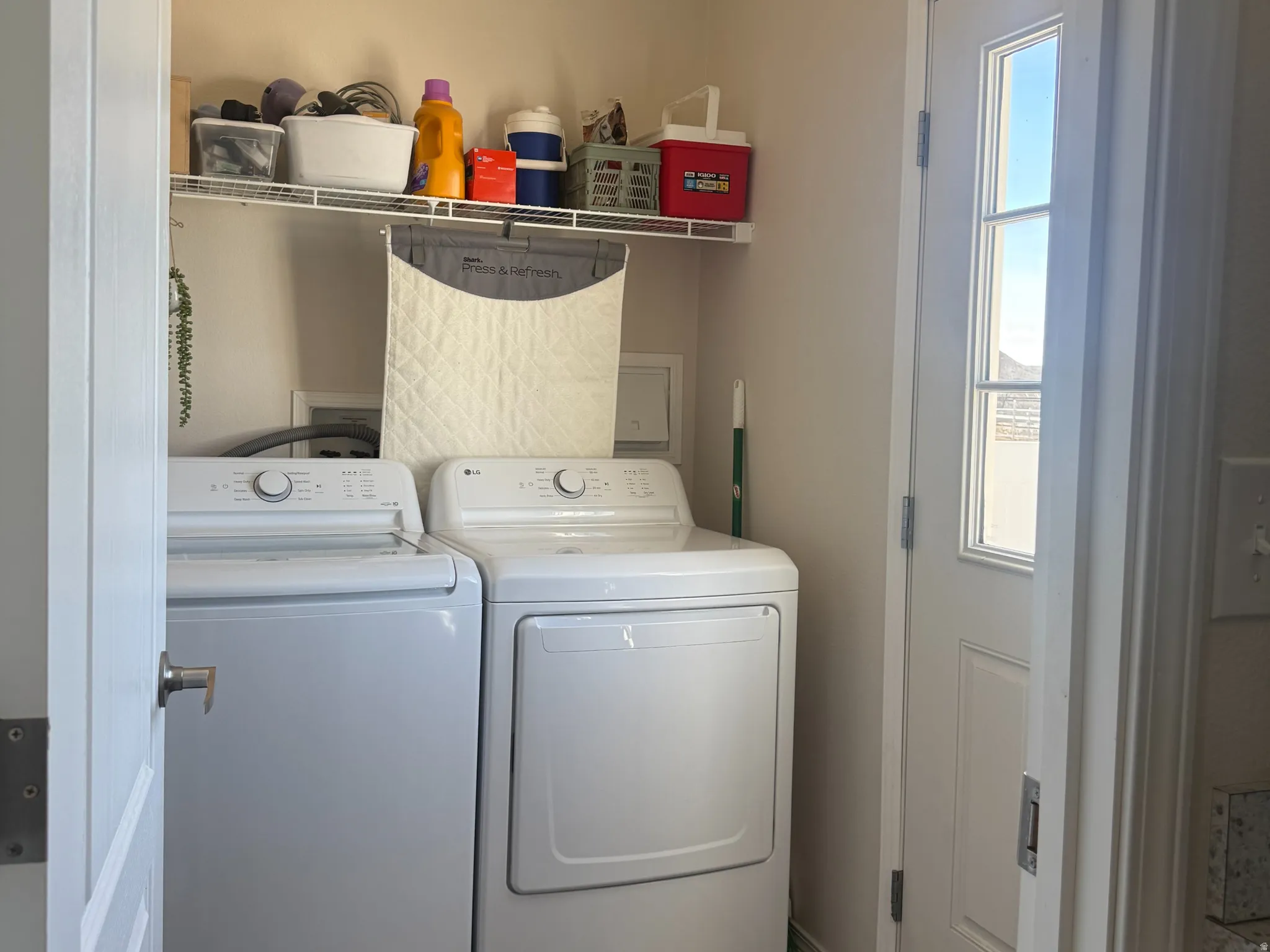 Laundry room with dark wood-style floors and washer and clothes dryer