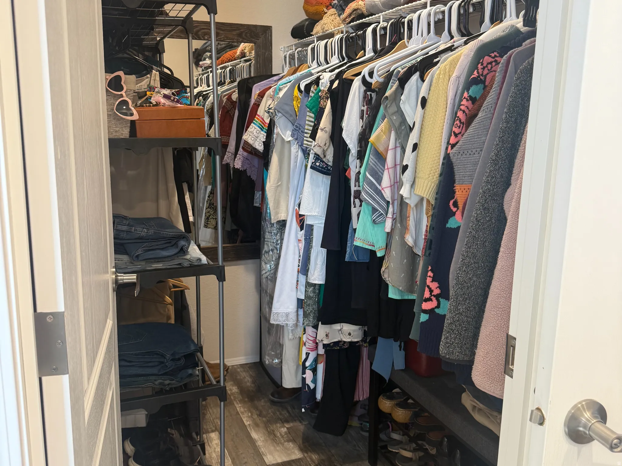 Walk in closet featuring dark wood finished floors located in the primary bedroom