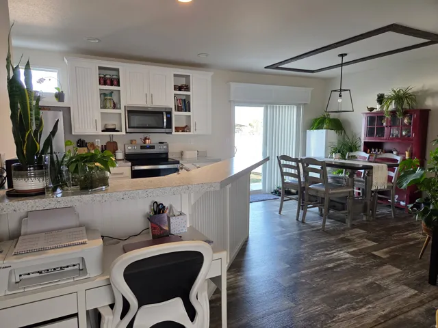 Kitchen with light countertops, stainless steel appliances, white cabinetry, and healthy amount of natural light