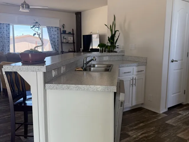 Kitchen with a peninsula, a breakfast bar, open floor plan, and dark wood-style flooring