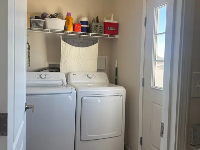 Laundry room with dark wood-style floors and washer and clothes dryer