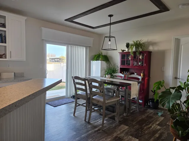 Dining area with dark wood-style floors showing sliding door that goes to the back yard