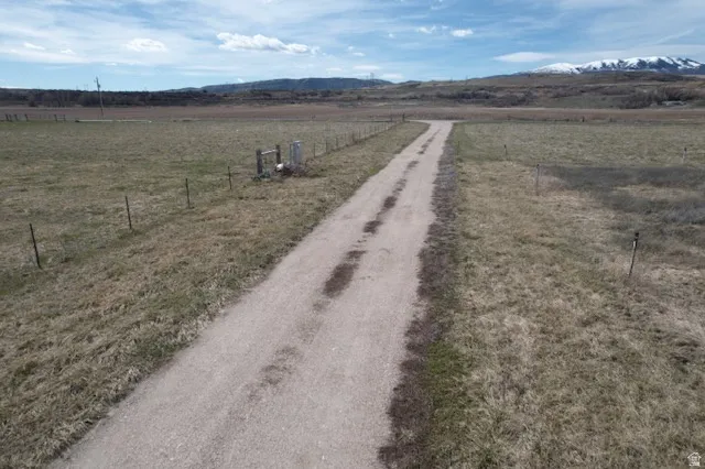 View of dirt / gravel road featuring a rural view and a mountain view