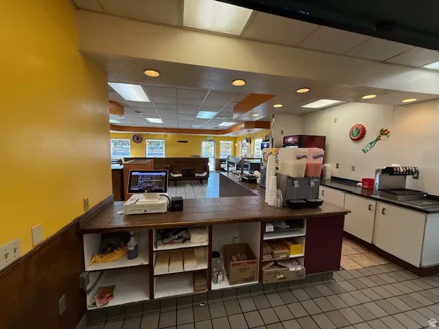 Kitchen featuring a paneled ceiling and white cabinetry