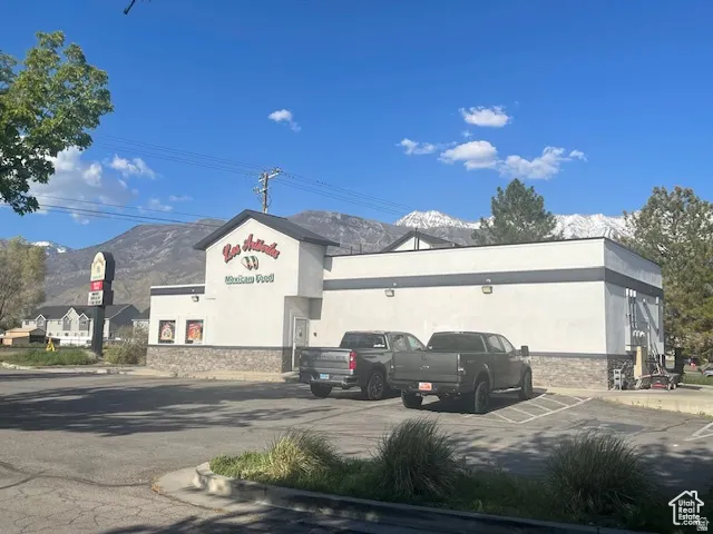 View of building exterior featuring a mountain view and uncovered parking