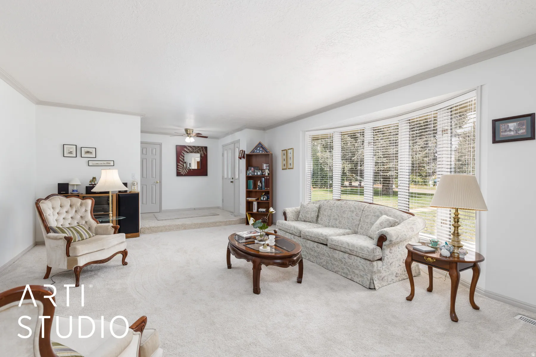 Formal living area with ornamental molding and a ceiling fan