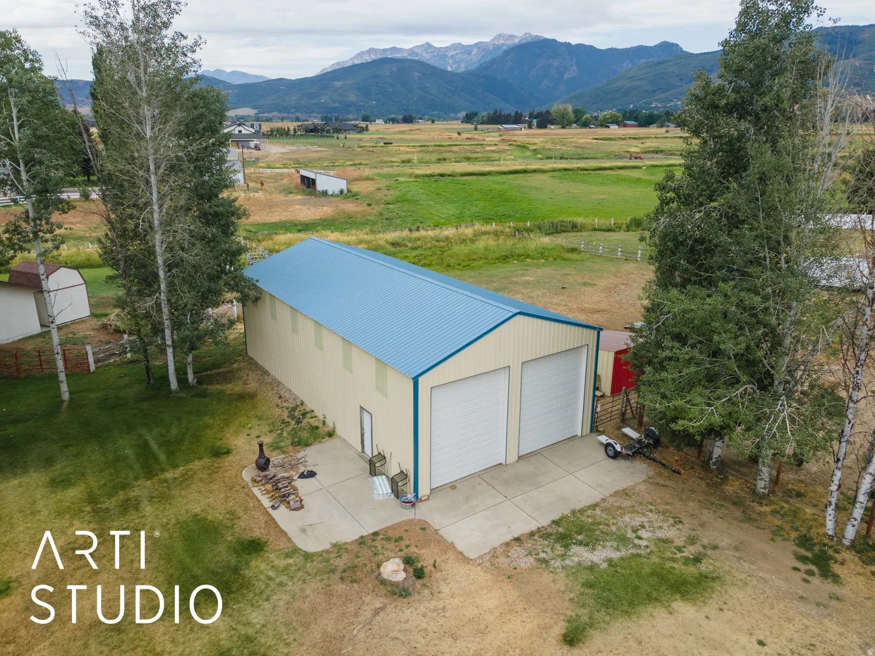 Aerial view of sparsely populated area featuring a pastoral area and a mountainous background