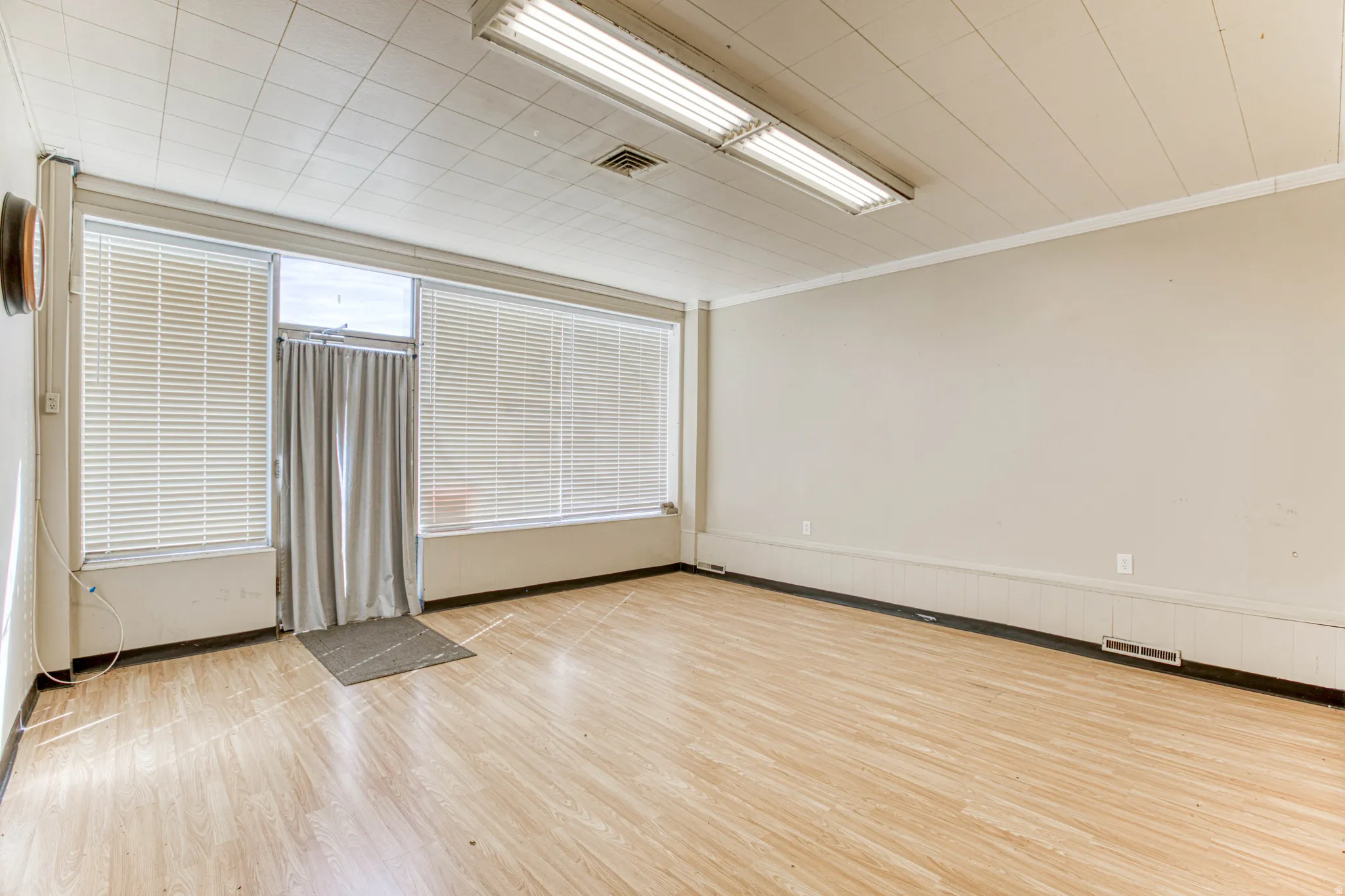 Empty room with light wood-type flooring and ornamental molding