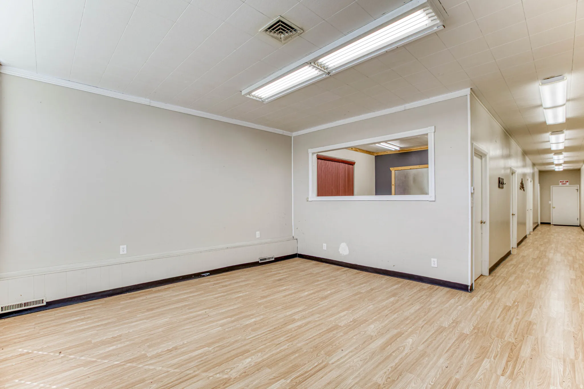 Spare room with light wood-type flooring and ornamental molding