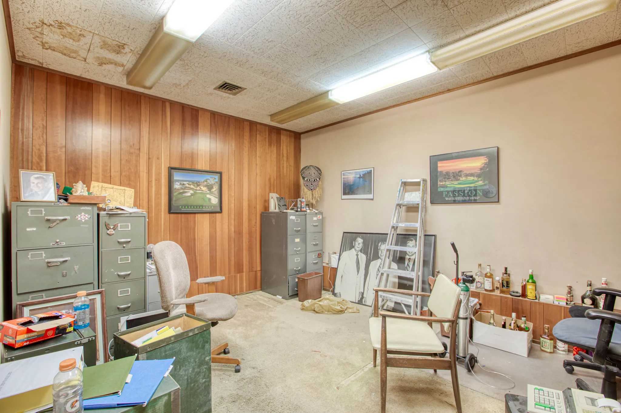 Carpeted office space featuring wood walls
