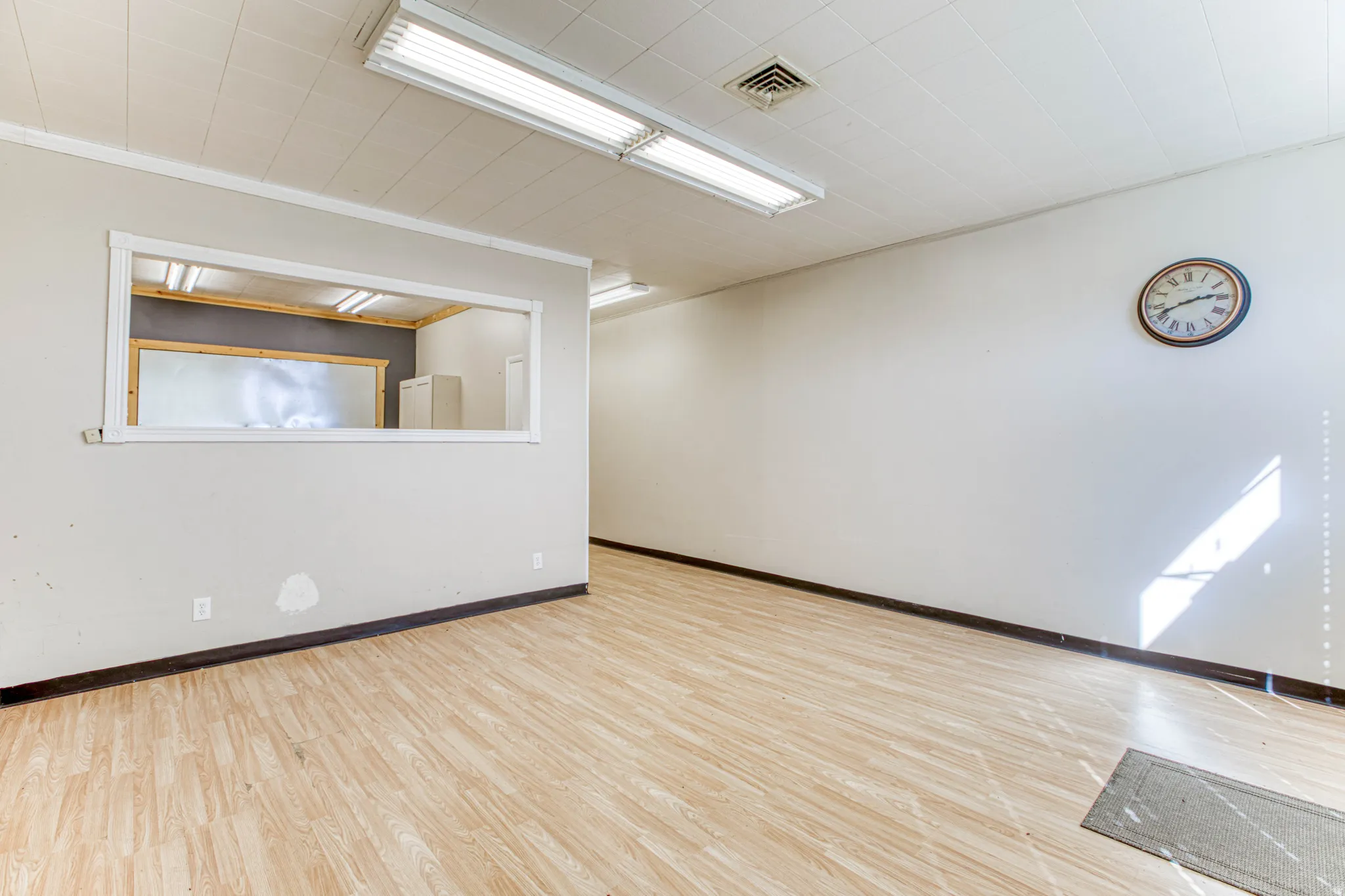 Spare room featuring light wood-style flooring and baseboards
